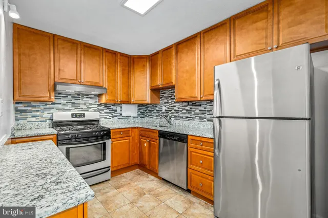 a kitchen with stainless steel appliances granite countertop a refrigerator sink and cabinets