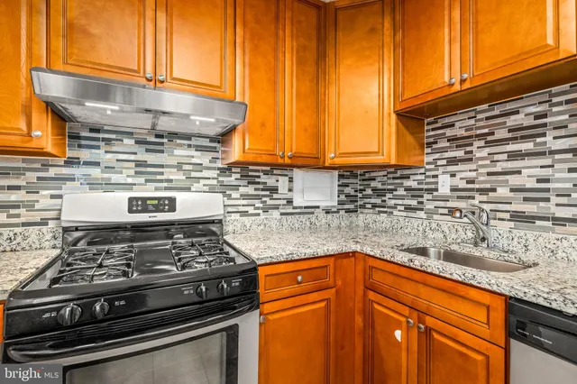 a kitchen with granite countertop cabinets and a stove top oven