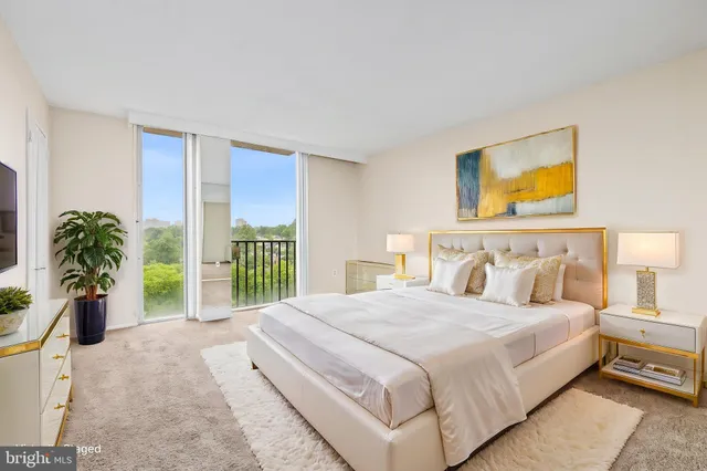 a bedroom with a balcony a bed and a potted plant