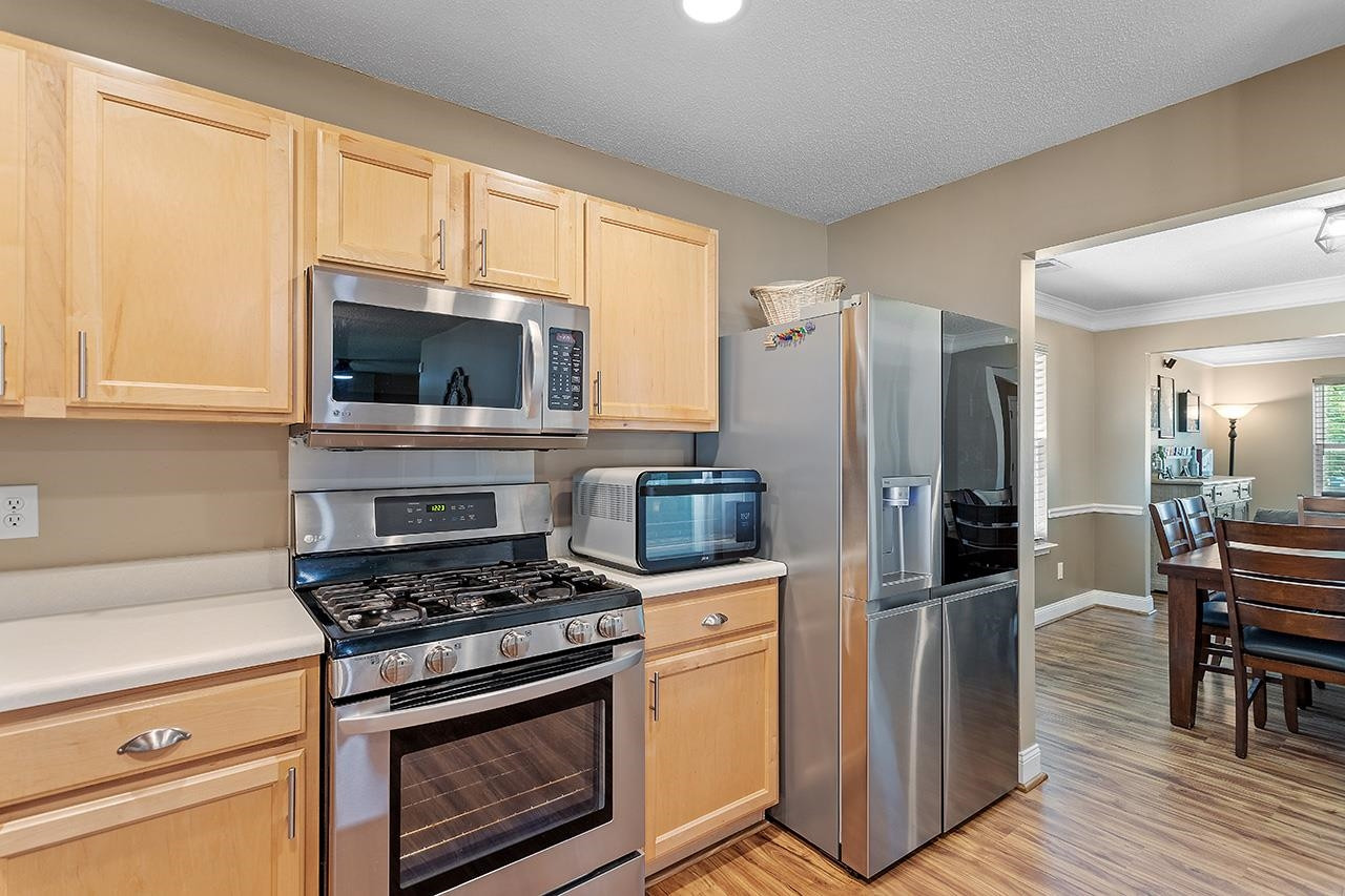 6 Esterbrook Court Durham, NC 27703 - Photo 10 of 31 a kitchen with cabinets stainless steel appliances and wooden floor