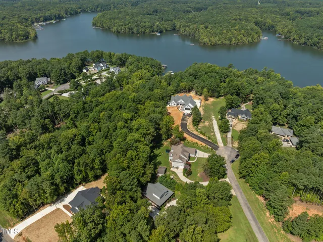 an aerial view of a house with a yard and lake view