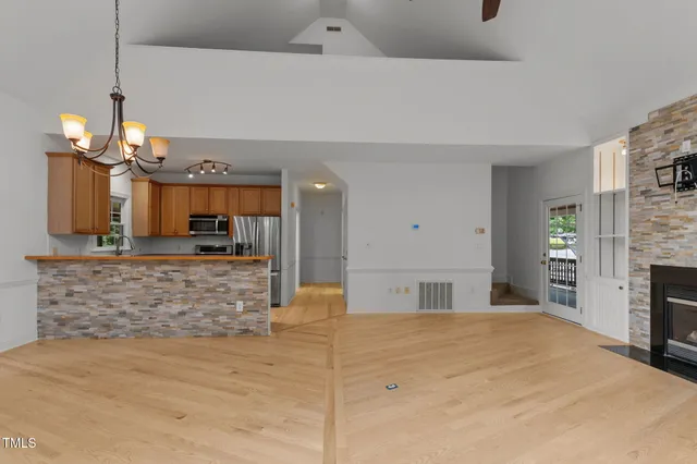a large kitchen with kitchen island a sink stainless steel appliances and a fireplace