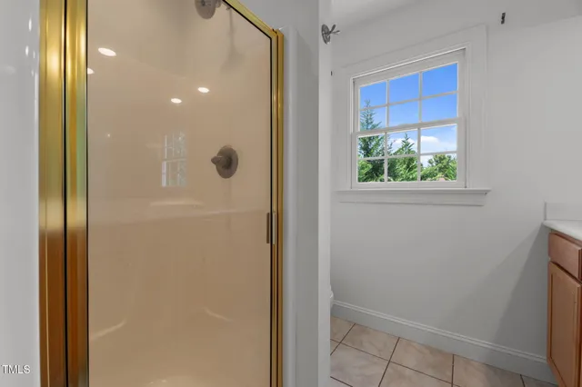 a bathroom with a glass shower door and a window