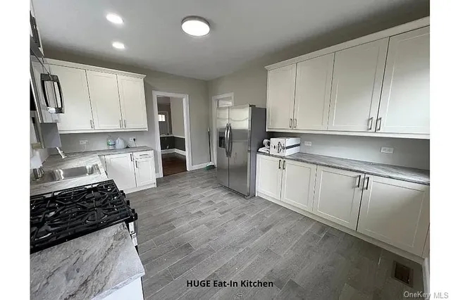 a kitchen with white cabinets and appliances