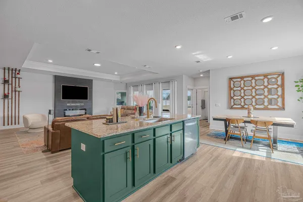 a kitchen with stainless steel appliances granite countertop a sink and a living room