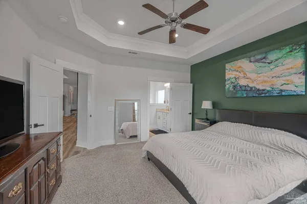 a spacious bedroom with a bed and a flat screen tv