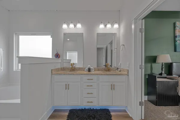 a bathroom with a granite countertop sink a light fixture and a mirror