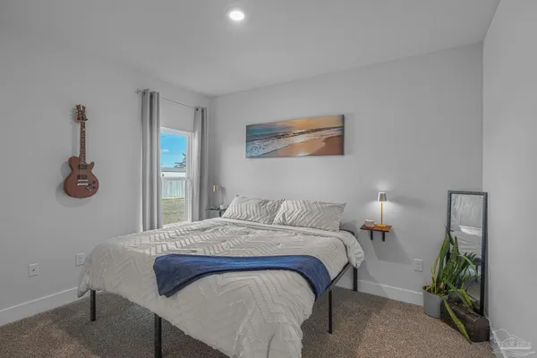 a bedroom with a bed and a potted plant