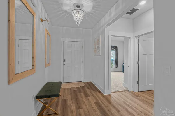 a view of a hallway to a bedroom with wooden floor and closet