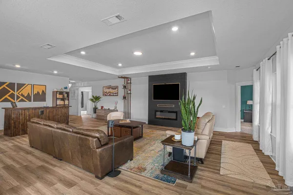 a living room with furniture wooden floor and a flat screen tv