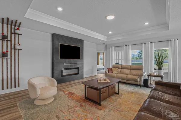 a living room with furniture a flat screen tv and a large window