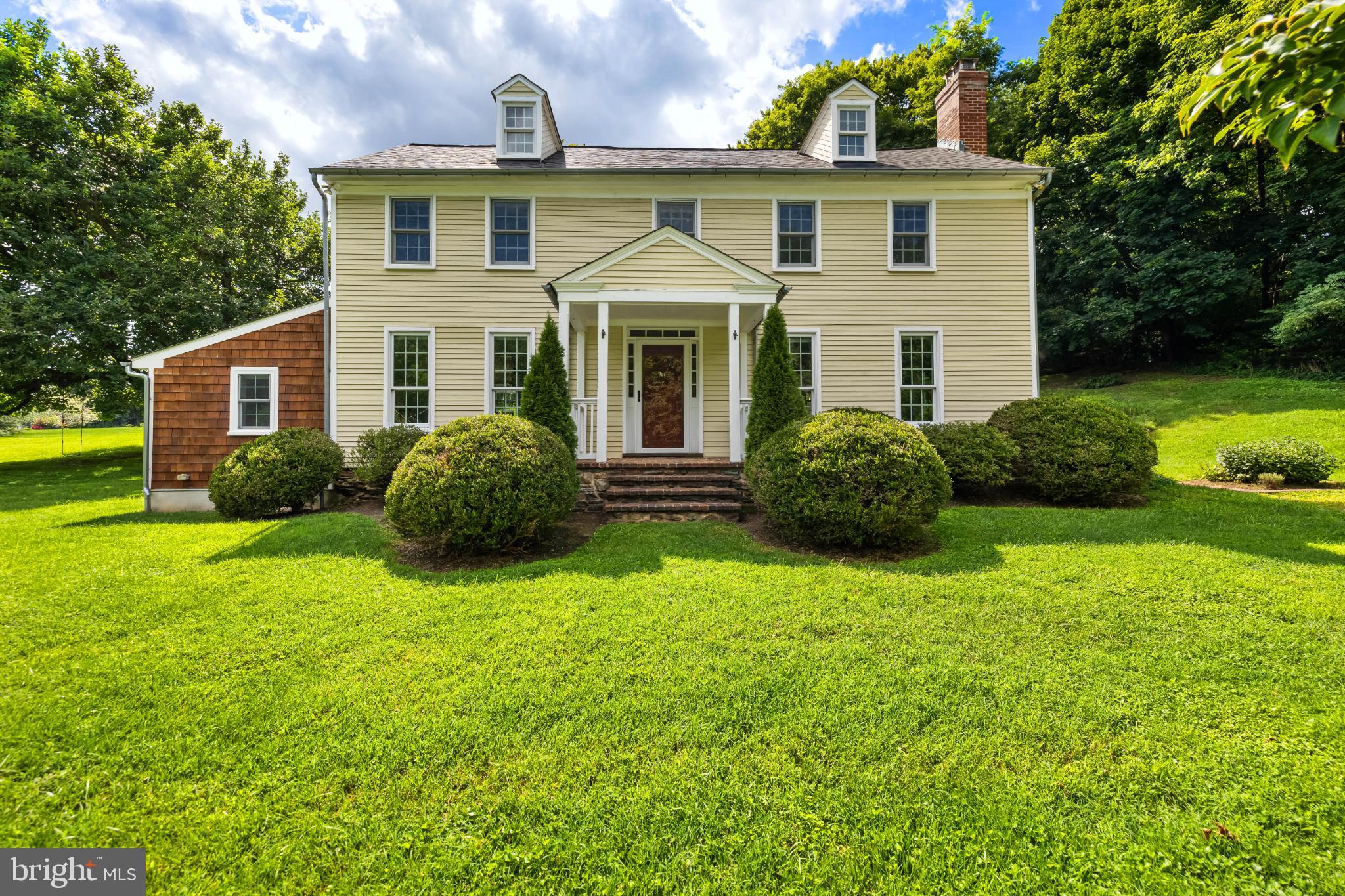 Charming colonial home amidst lush greenery.
