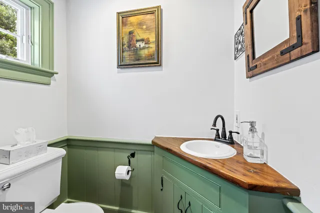 a bathroom with a sink mirror vanity and toilet