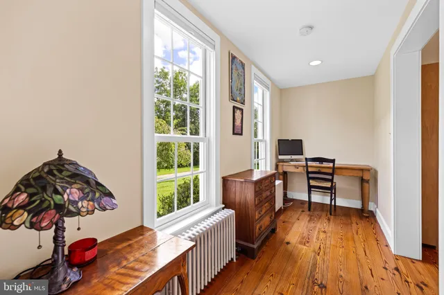 a view of a workspace with furniture and a window