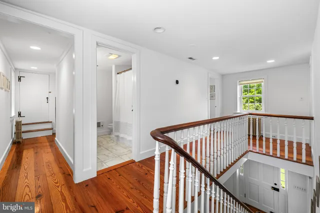a view of a hallway with wooden floor and staircase