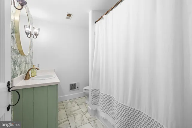 a bathroom with a sink a toilet and shower curtain