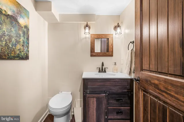 a bathroom with a granite countertop toilet sink and mirror