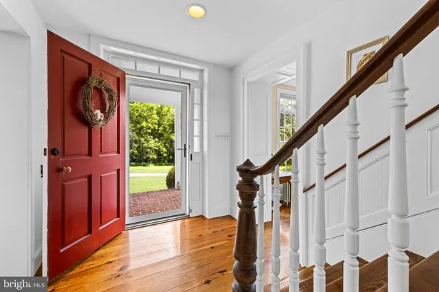 a view of an entryway with wooden floor and door
