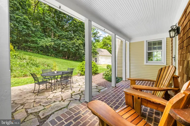a view of a patio with table and chairs with wooden floor and fence