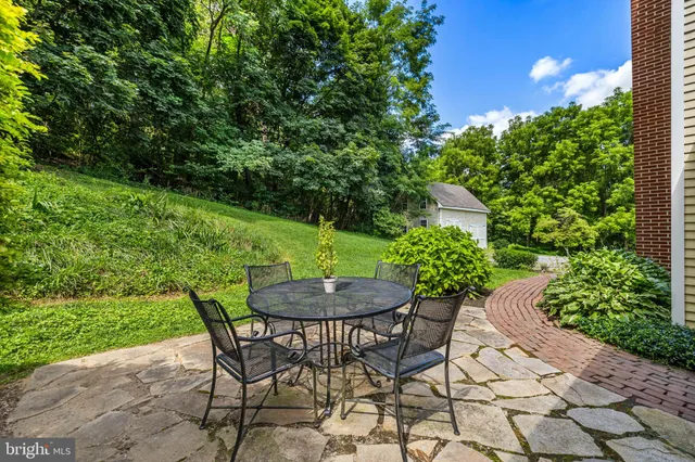 a backyard of a house with a yard table and chairs