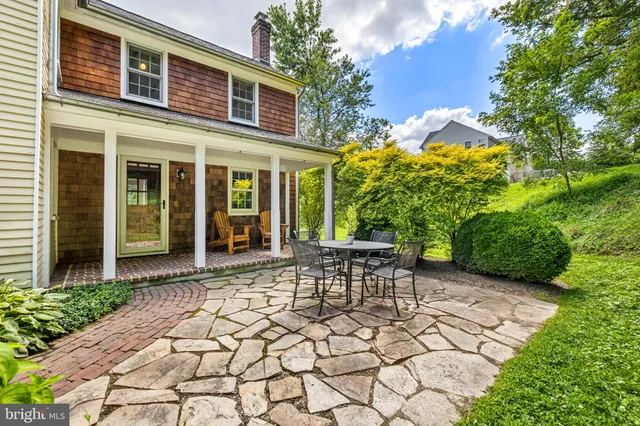 a patio with table and chairs and potted plants