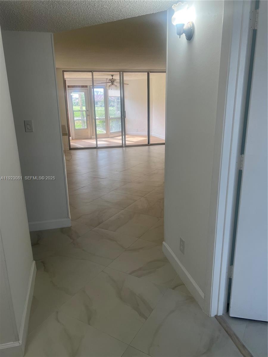 9510 Seagrape Drive, Unit 101 Davie, FL 33324 - Photo 13 of 18 wooden floor in an empty room with a window