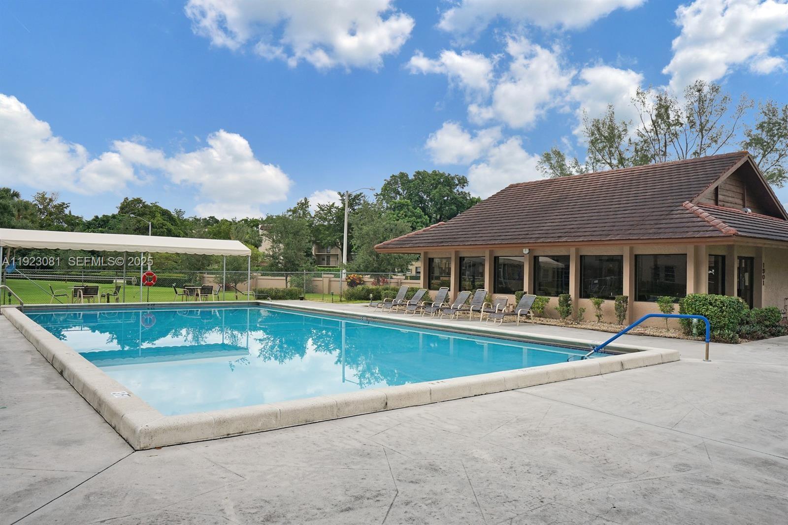 9510 Seagrape Drive, Unit 101 Davie, FL 33324 - Photo 17 of 18 a view of a house with pool and chairs