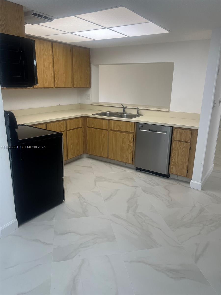 9510 Seagrape Drive, Unit 101 Davie, FL 33324 - Photo 10 of 18 a kitchen with a sink and cabinets