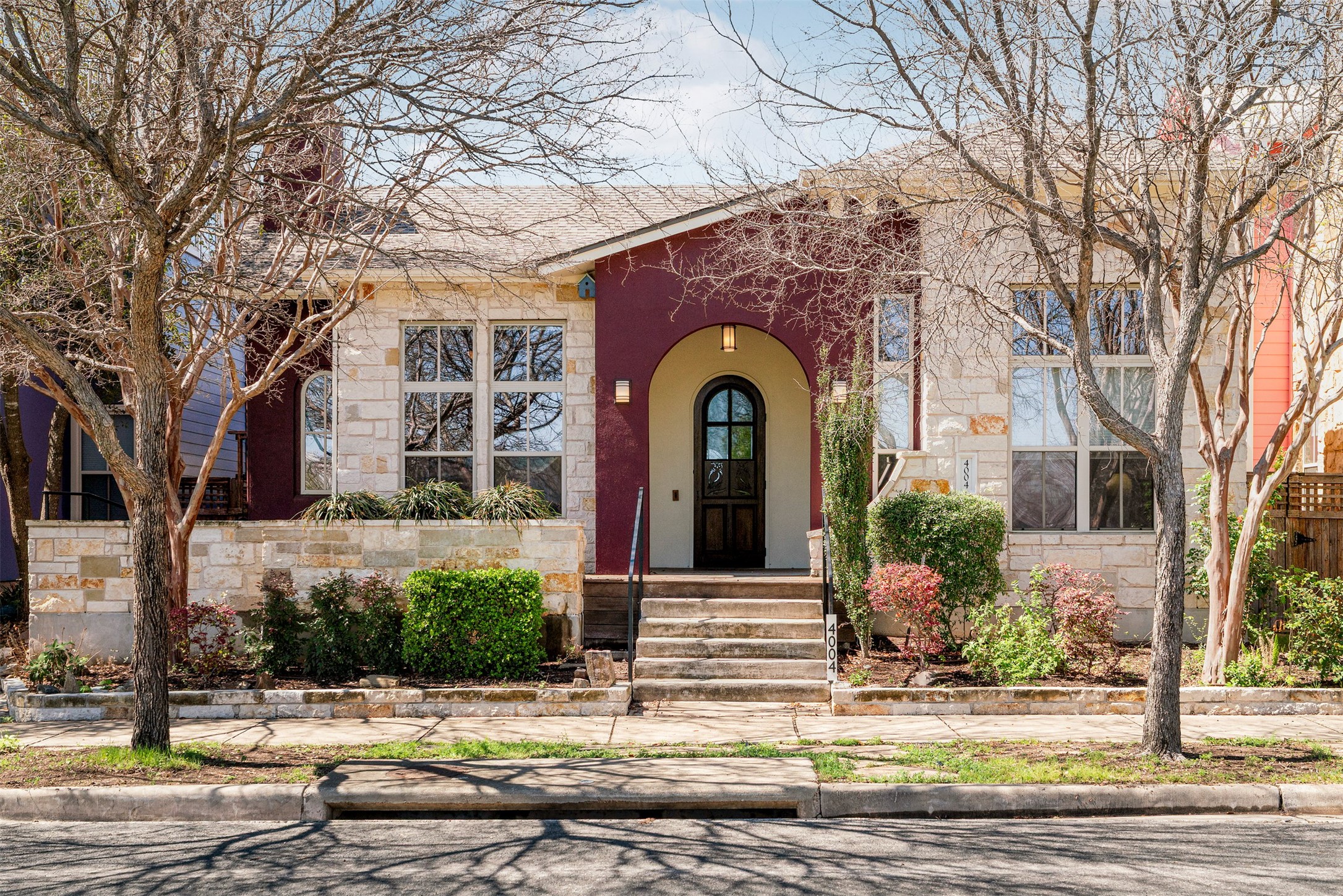 4004 Pinckney Street Austin, TX 78723 - Photo 1 of 1 Mueller home with a beautifully manicured front yard and mature trees lining the sidewalk, creating a welcoming approach from the street