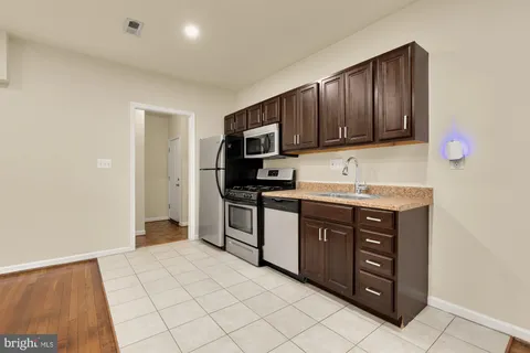 a kitchen with stainless steel appliances granite countertop a refrigerator and a stove top oven