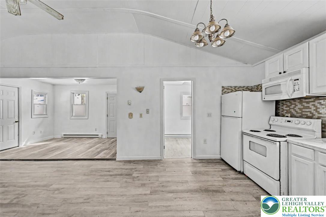 108 Mink Lane Bushkill, PA 18324 - Photo 14 of 33 a kitchen with stainless steel appliances granite countertop a refrigerator a stove oven and white cabinets with wooden floor