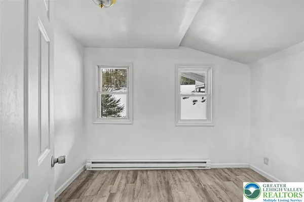 a view of room with window and wooden floor