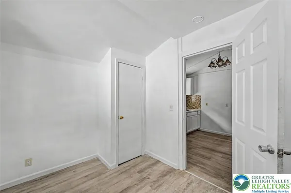 a view of an empty room with closet and a window