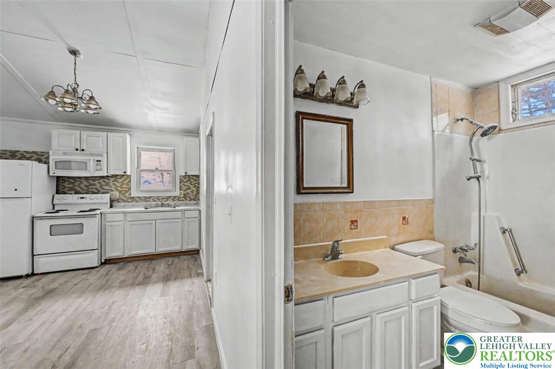 108 Mink Lane Bushkill, PA 18324 - Photo 23 of 33 a kitchen with a refrigerator sink and white cabinets
