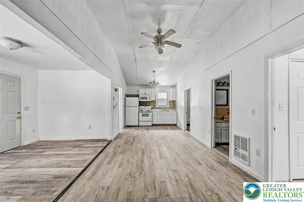 a view of a kitchen with a sink and dishwasher a refrigerator with wooden floor