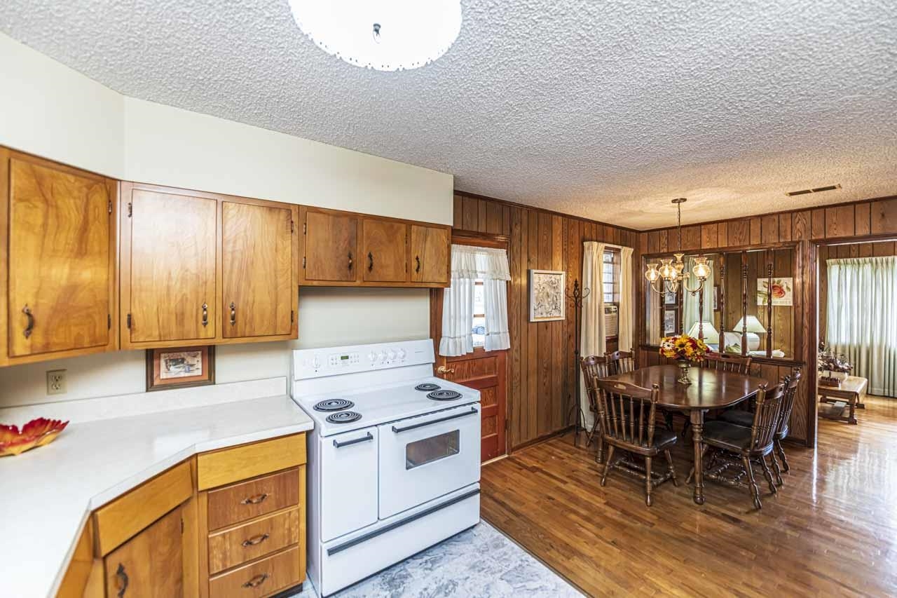 3285 Munford Giltedge Road Drummonds, TN 38023 - Photo 10 of 32 a kitchen with stainless steel appliances a stove a sink a dining table and chairs with wooden floor