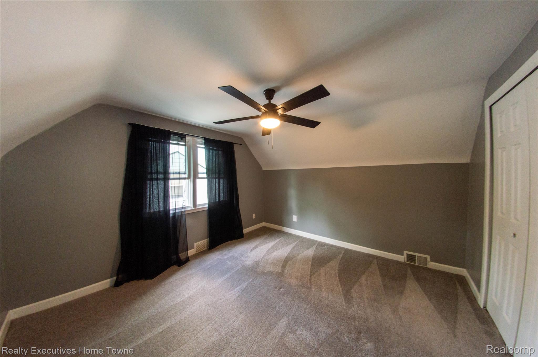 2676 Cumberland Road Berkley, MI 48072 - Photo 18 of 38 Attic room featuring sloped ceilings, a window with sheer black curtains, and a ceiling fan with integrated lighting