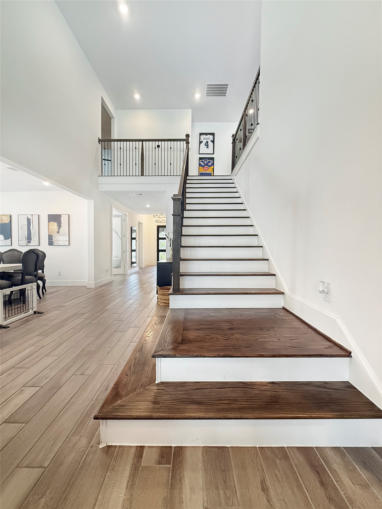 26918 Swanborough Road Spring, TX 77389 - Photo 25 of 50 A dramatic two-story staircase with rich wood treads and wrought-iron railings serves as the architectural centerpiece of the home, framed by soaring ceilings and an open loft overlook.