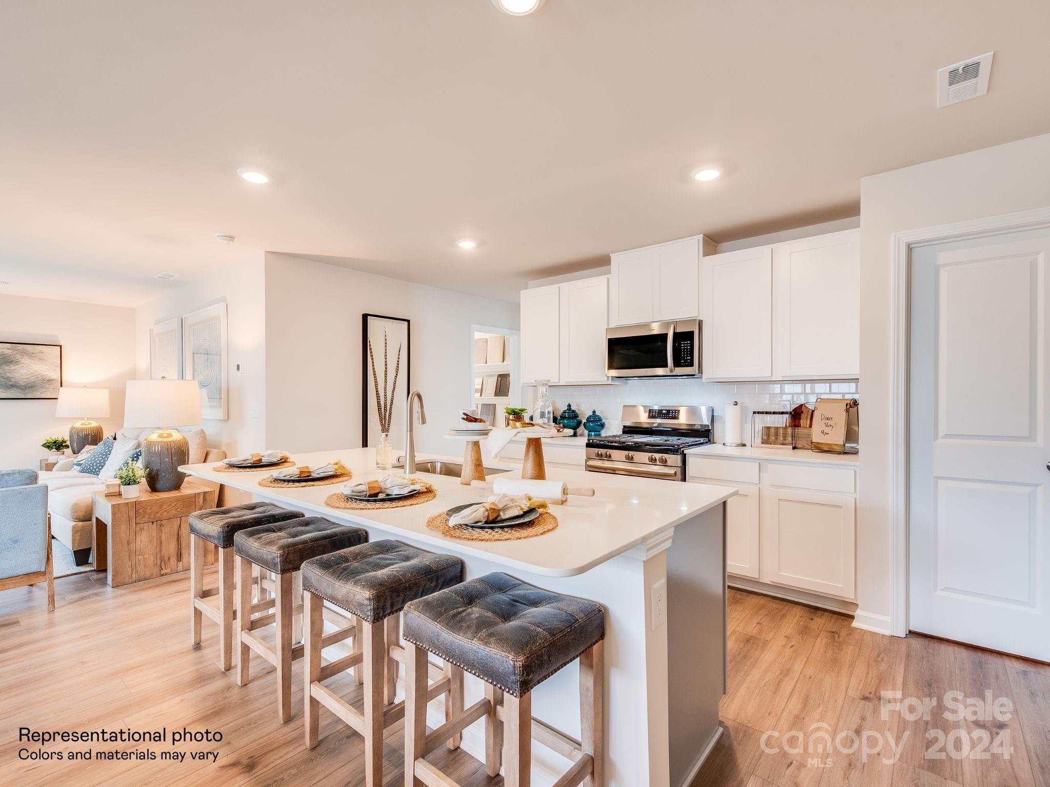 13228 Hampton Bay Lane Charlotte, NC 28262 - Photo 2 of 25 a kitchen with a dining table chairs and a refrigerator