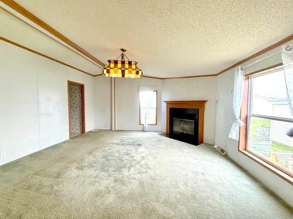 a view of an empty room with a fireplace and a window