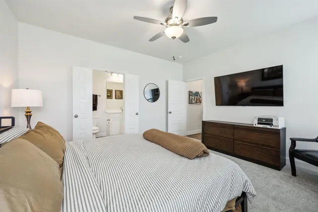 a bedroom with a bed tv and window