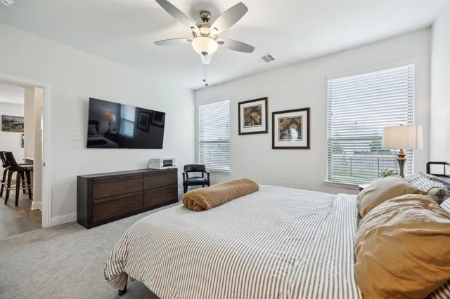 a bedroom with a bed window and a flat screen tv
