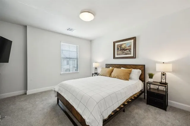 a bedroom with a bed and a night stand