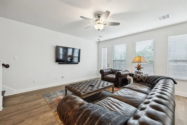 a living room with furniture ceiling fan and a flat screen tv