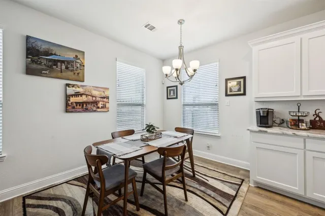 a view of a dining room with furniture a chandelier and wooden floor
