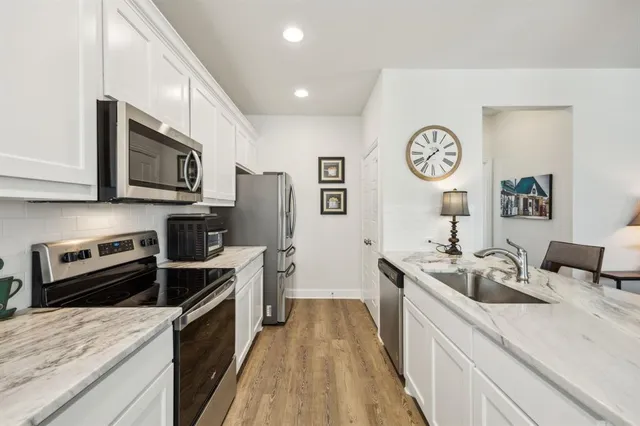 a kitchen with stainless steel appliances a stove sink and cabinets