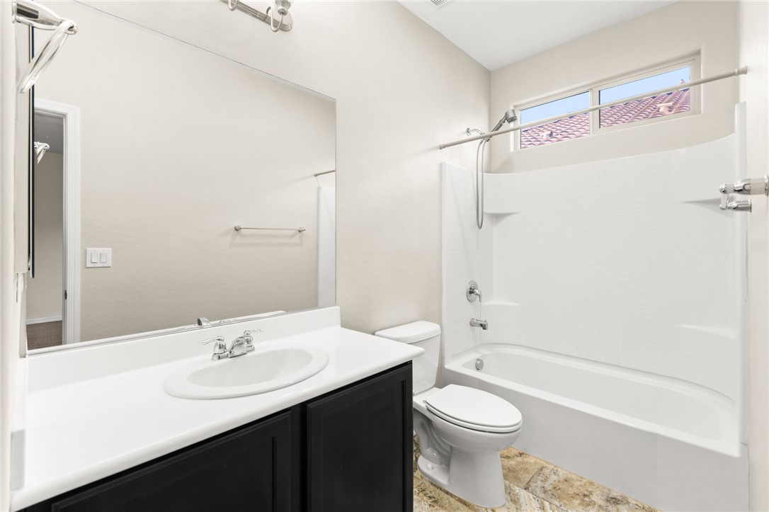 11048 Prairie Grove Road Las Vegas, NV 89179 - Photo 64 of 75 A well-appointed bathroom features a single vanity, toilet, and a combined shower-tub unit.