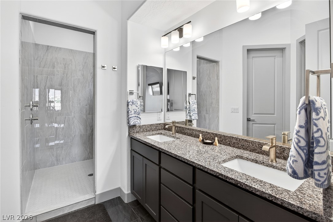 1460 Blue Ridge Trail Mesquite, NV 89027 - Photo 17 of 39 A well-appointed primary bathroom showcases dual vanities with granite counters and a spacious walk-in shower.