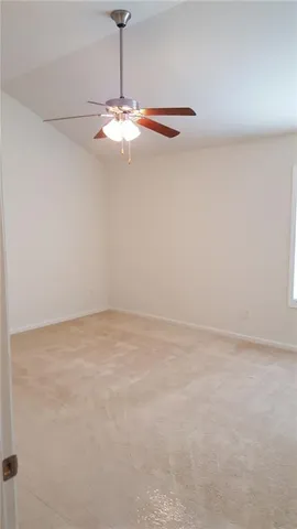 a view of a room with a ceiling fan and a fan