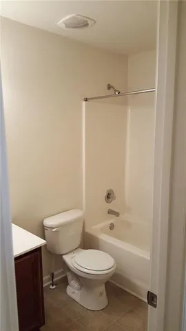 a white toilet sitting next to a bath tub